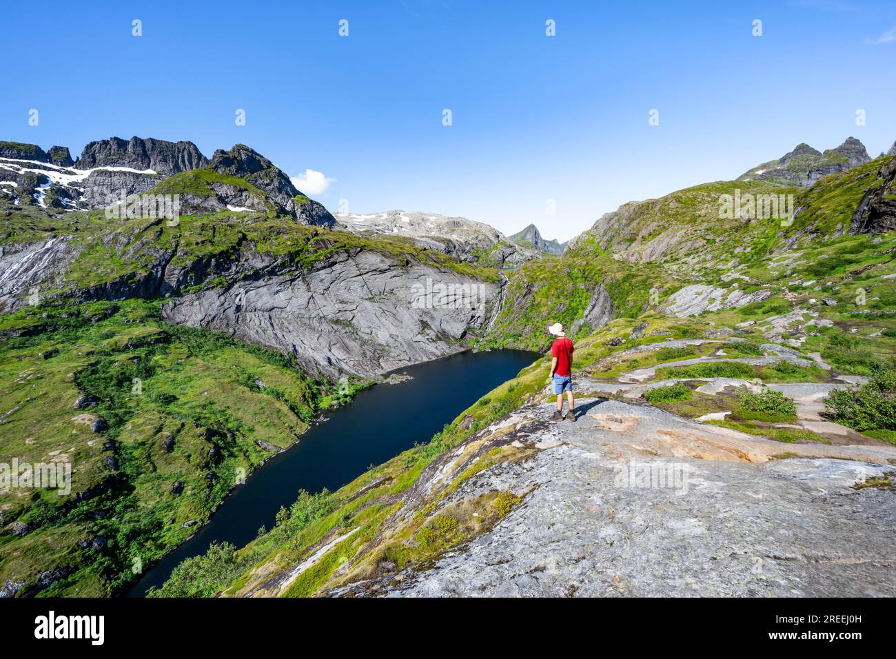 Alpinisti sul sentiero escursionistico fino al rifugio Munkebu, vista del lago Tridalsvatnet e del paesaggio montano, Moskenesoya, Lofoten, Nordland, Norvegia Foto Stock