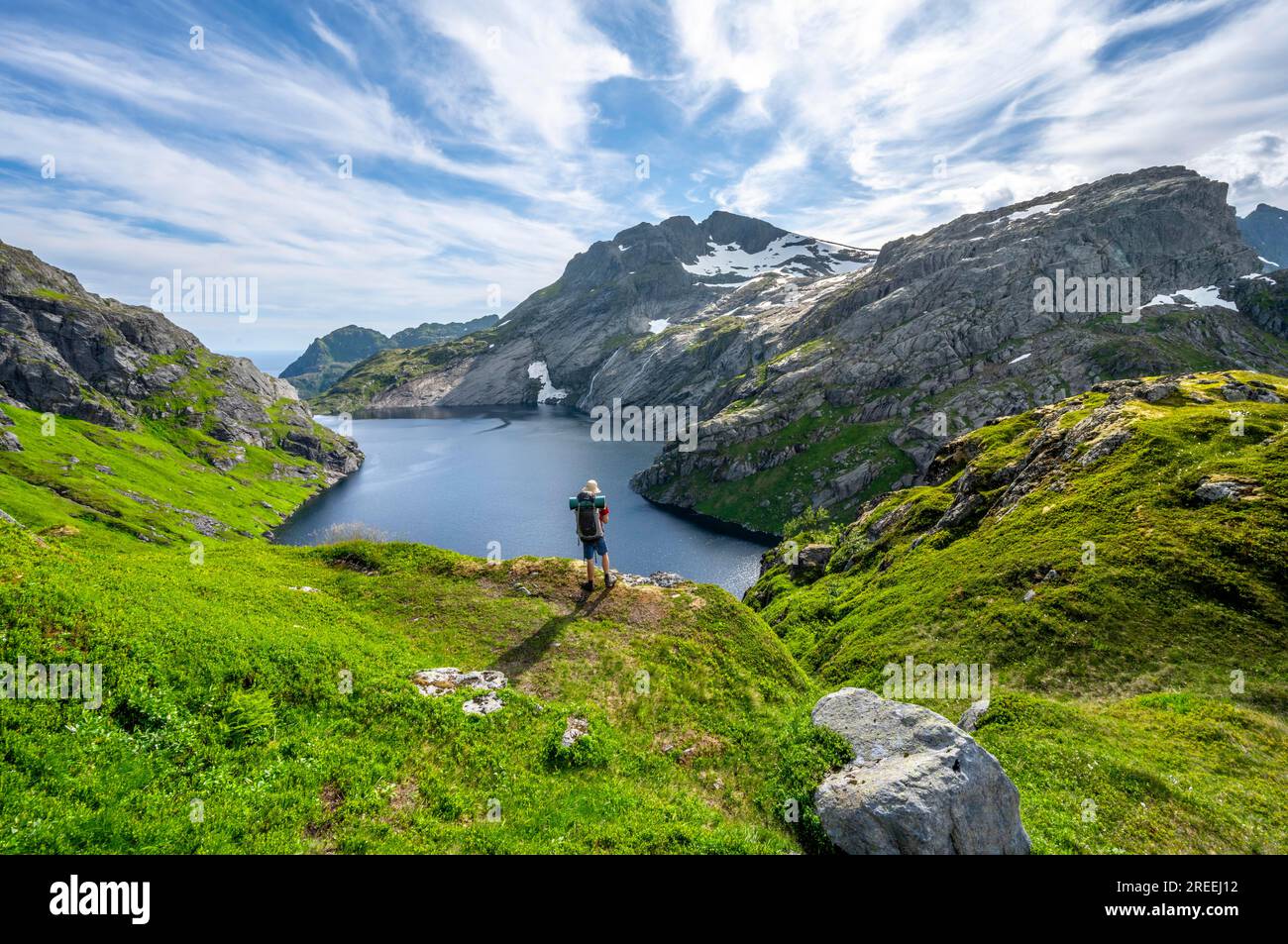 Alpinisti sul sentiero escursionistico fino al rifugio Munkebu, al lago Fjerddalsvatnet e al paesaggio montano, Moskenesoya, Lofoten, Nordland, Norvegia Foto Stock