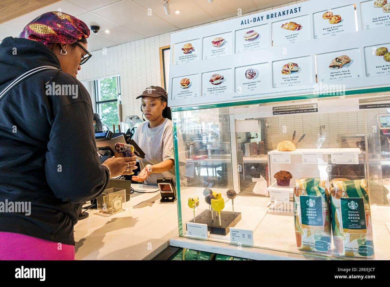 Atlanta Georgia, Starbucks Coffee, interni interni interni, cliente al banco, donna nera afroamericana barista lavoratrice, mostrando smartphon Foto Stock