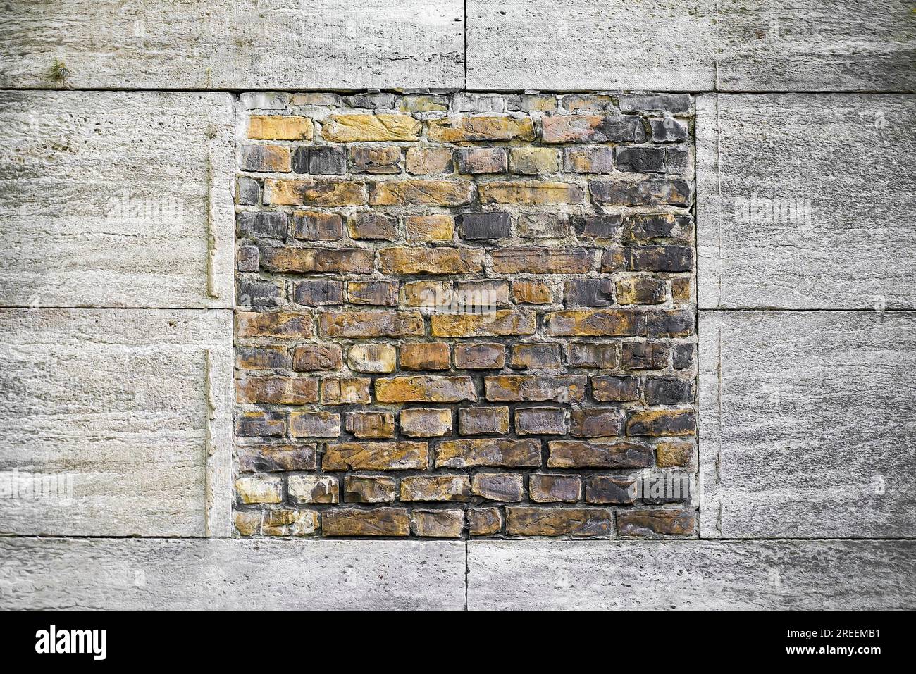 Parete di mattoni gialli incorniciata da piastre di granito Foto Stock