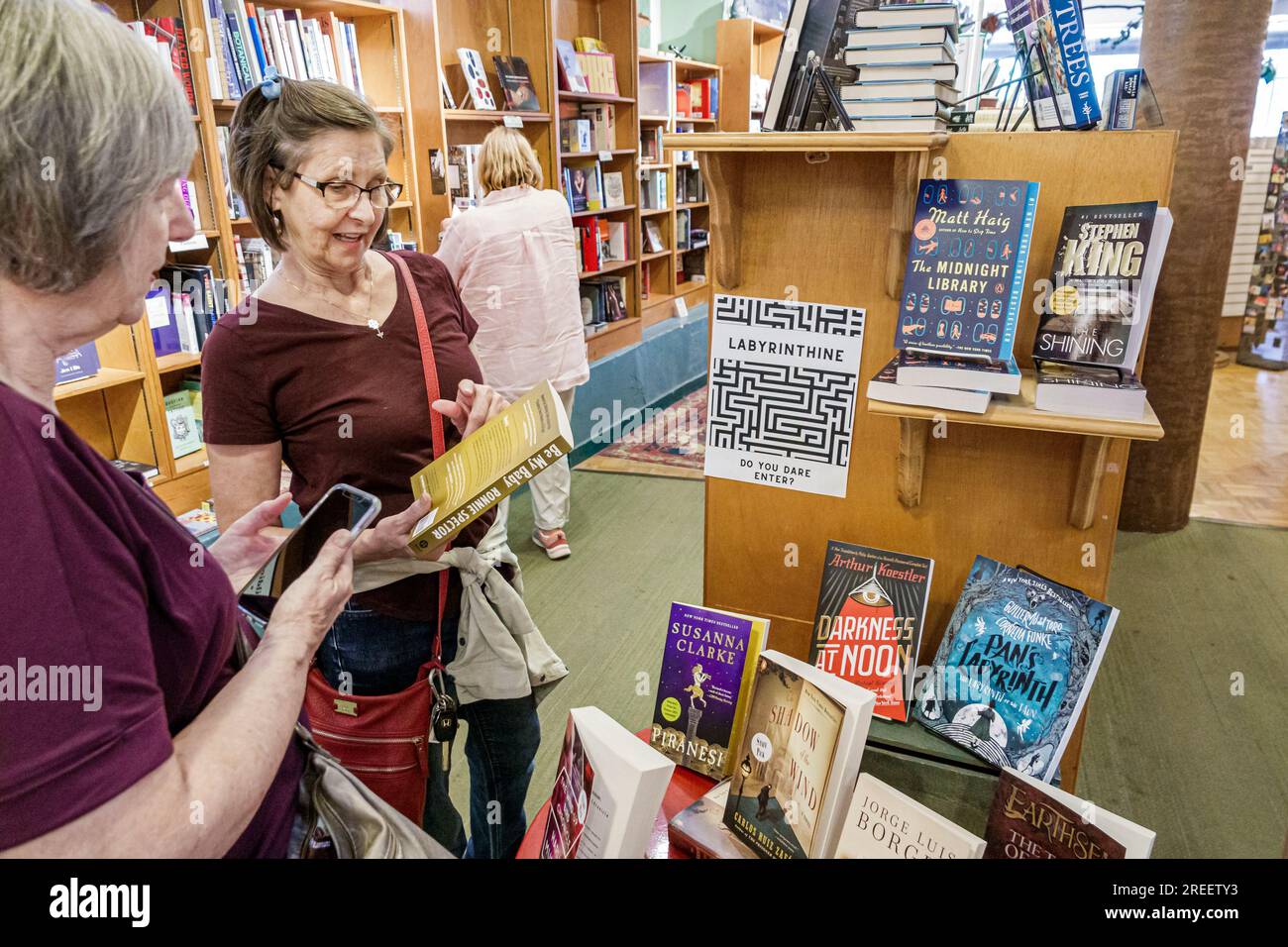 Asheville North Carolina, Malaprop's Bookstore Cafe, interni interni, scaffali in vendita per libri, donne anziane che parlano di un libro parlante Foto Stock