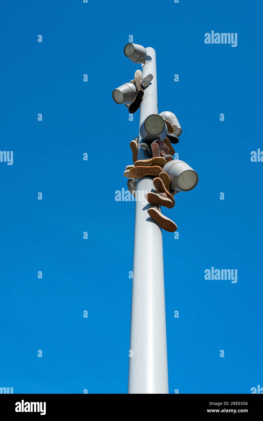 Scarpe da ginnastica appese a un palo luminoso moderno, Berlino, Germania Foto Stock