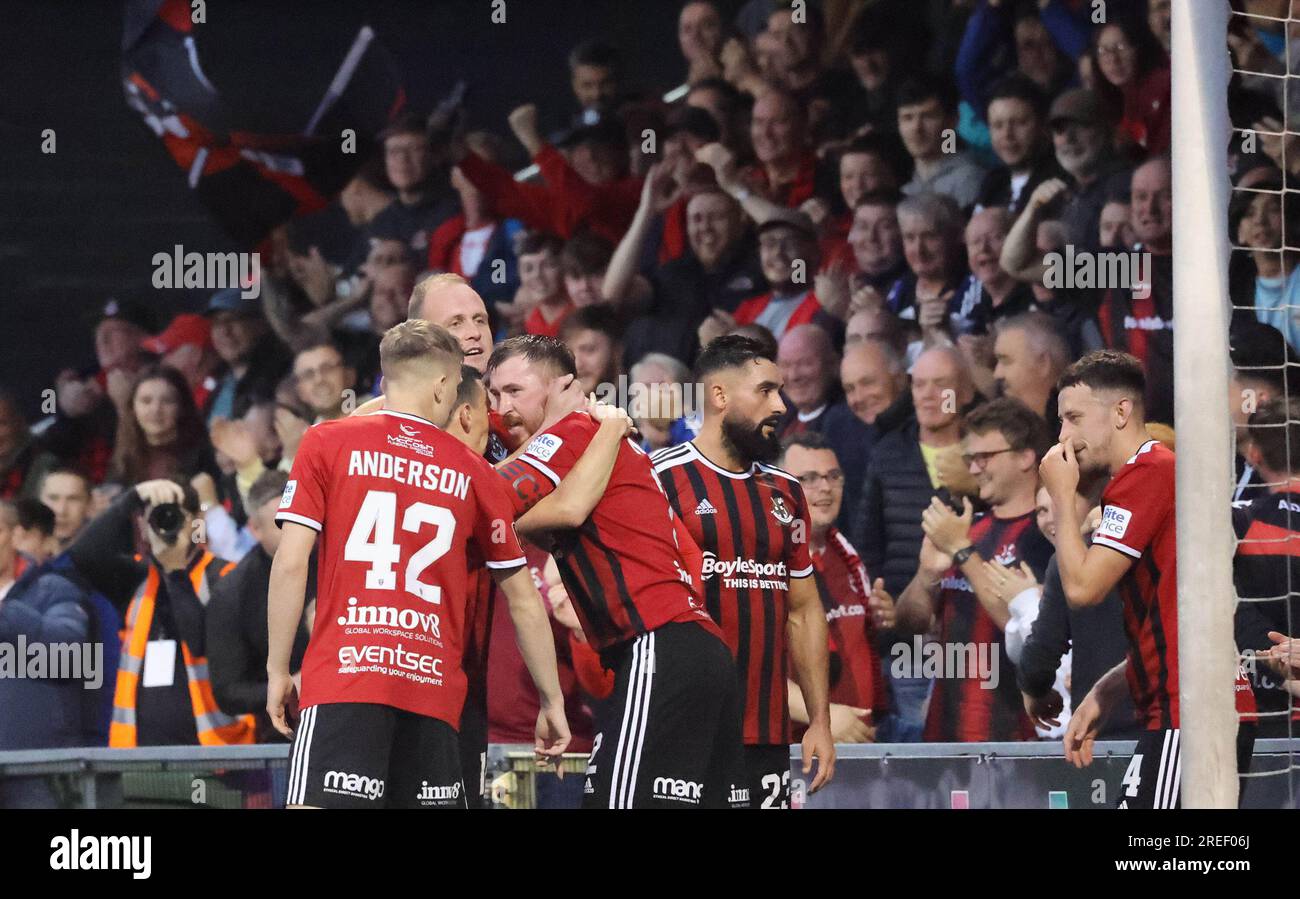 Seaview Stadium, Belfast, Irlanda del Nord, Regno Unito. 27 luglio 2023. UEFA Europa Conference League qualificazione secondo turno (andata) – Crusaders contro Rosenborg. Azione della partita di stasera al Seaview. (Crociati in rosso). Il capitano dei Crusaders Billy Joe Burns celebra il suo sforzo deviato che ha dato alla squadra di casa un pareggio di 2-2 a Belfast. Credito: CAZIMB/Alamy Live News. Foto Stock