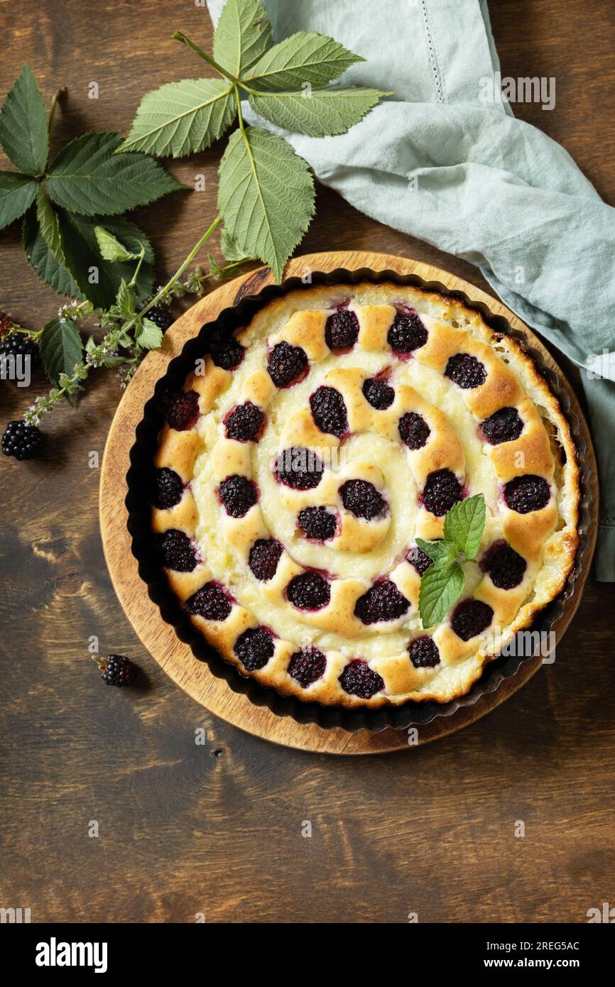 Torta di blackberry fatta in casa. Pasticceria vegana senza glutine, dessert vegani. Torta dolce con mora e crema pasticcera su un tavolo di legno. Vista dall'alto. Copia spazio. Foto Stock