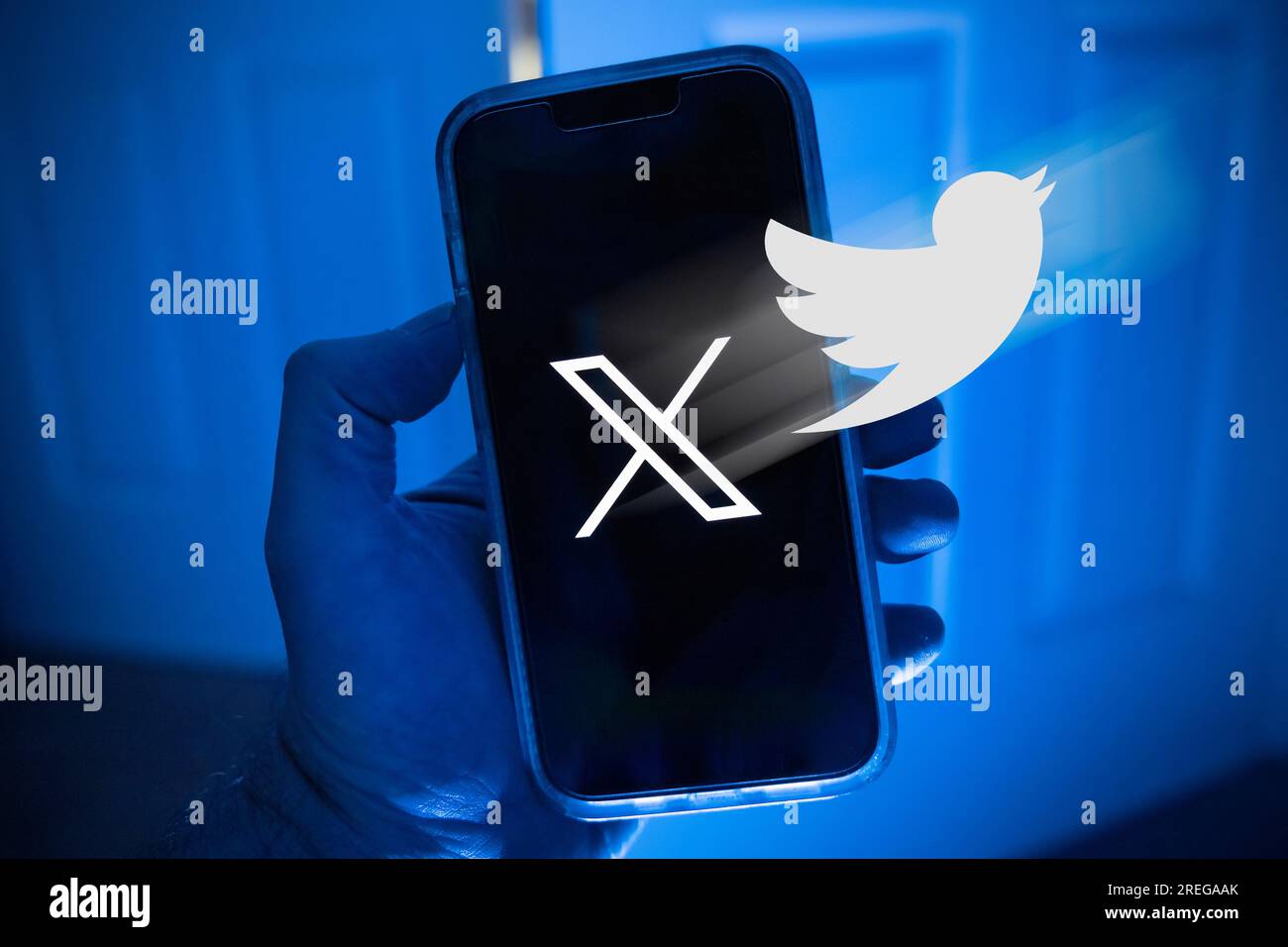 Telefono cellulare in una mano con il simbolo X, il nuovo nome della precedente app Twitter Foto Stock