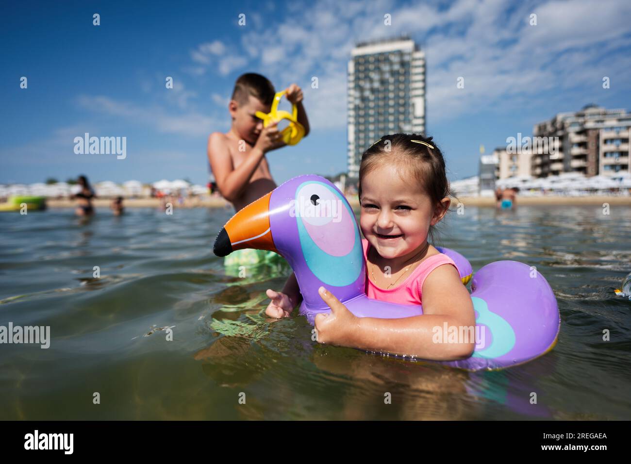 La bambina nuota in mare con un anello gonfiabile come il tucano. Foto Stock