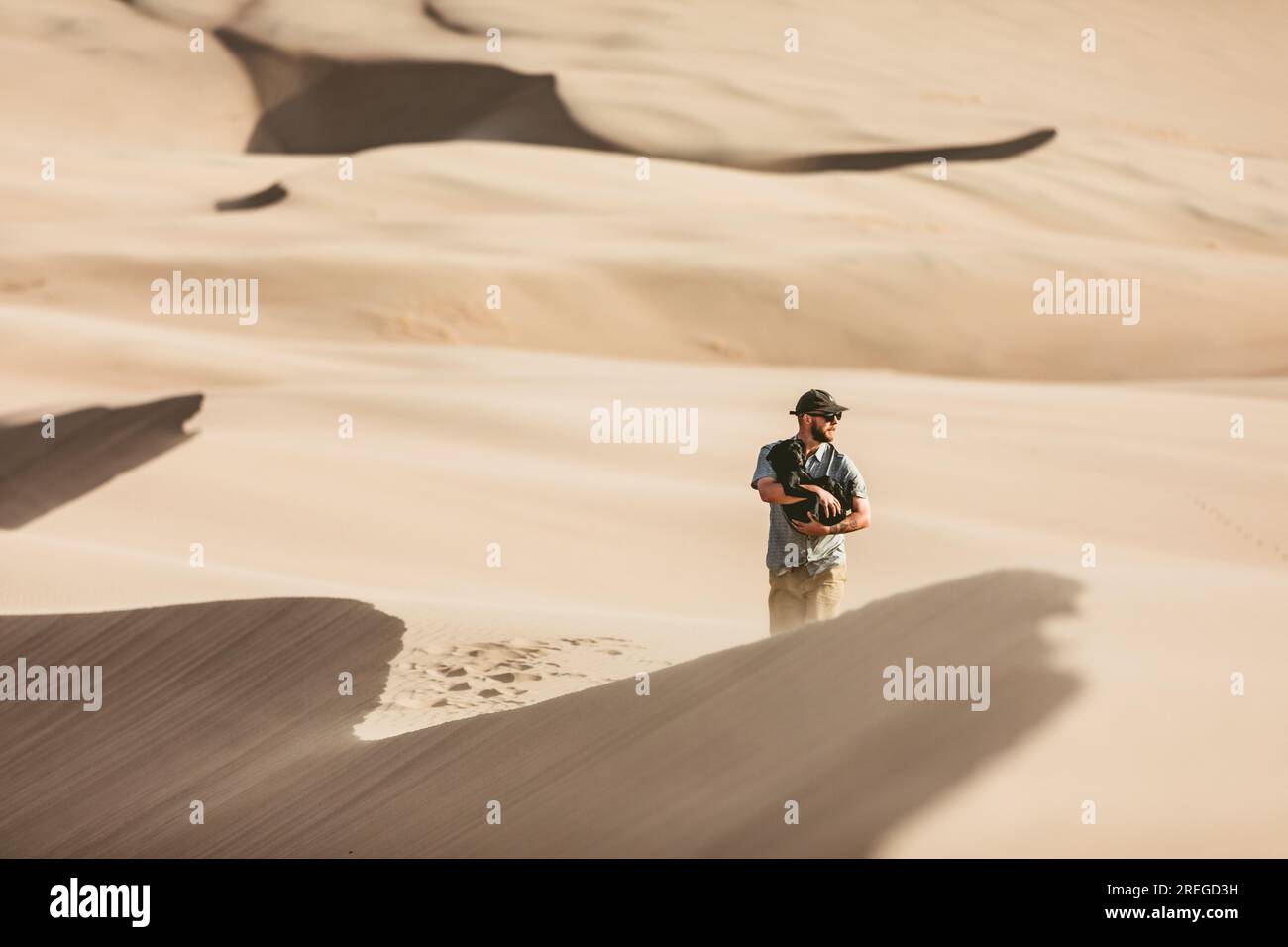 l'escursionista delle dune protegge il suo cucciolo dal vento in un grande parco di dune di sabbia Foto Stock
