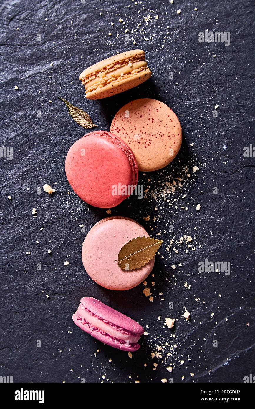 Macaron colorati su uno sfondo di marmo nero visto dall'alto Foto Stock