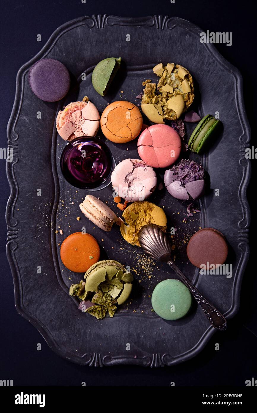 Macaron su un elegante piatto nero vintage visto dall'alto Foto Stock