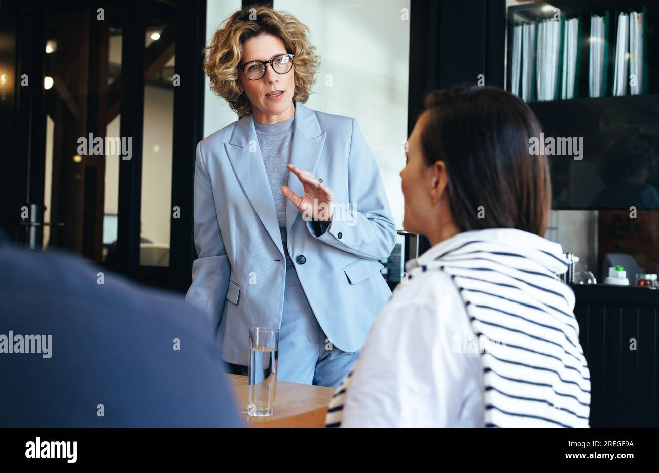 Donna professionale che conduce una riunione d'affari. Manager donna che pianifica un progetto con i suoi colleghi. professionisti aziendali che lavorano insieme in una di Foto Stock