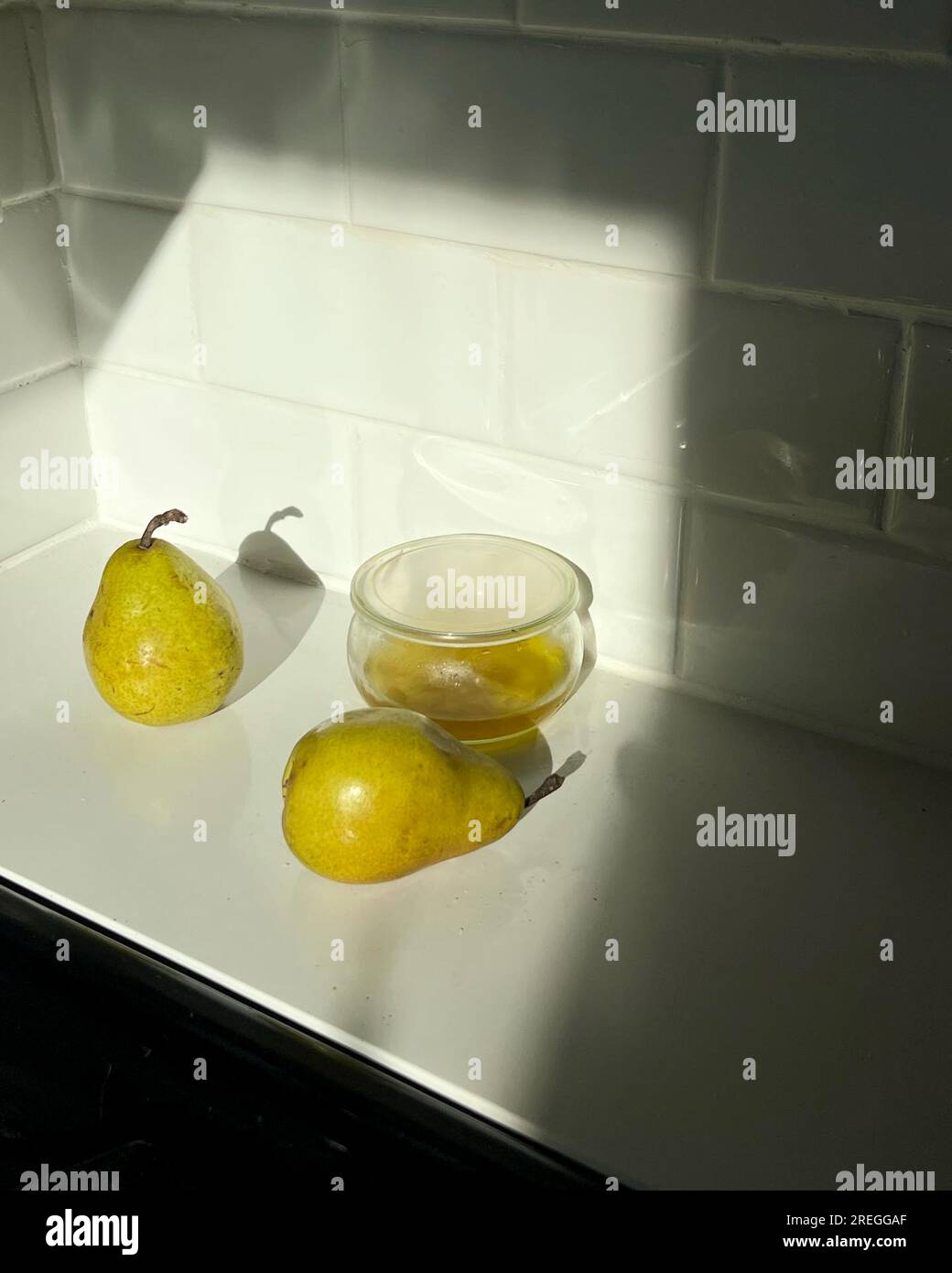 Due pere e un vasetto di olio d'oliva su un bancone della cucina Foto Stock