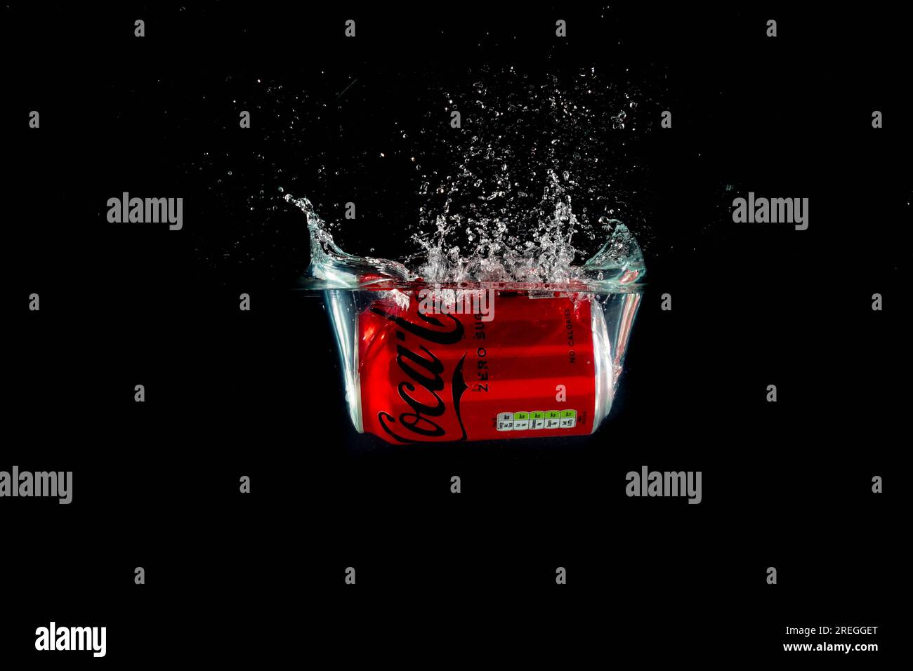 Londra, Regno Unito, 24 luglio 2023: Una lattina di Coca Cola Zero che si getta in acqua su uno sfondo nero Foto Stock