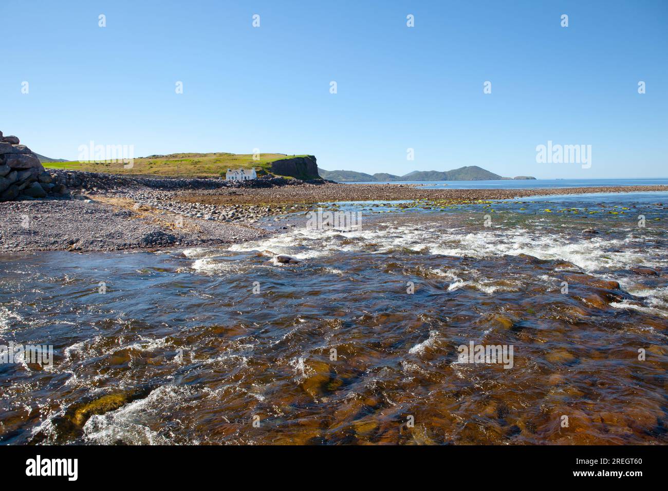 Cottage solitario alla foce del fiume Currane sul lungomare di Waterville, Spunkane, Ballinskelligs Bay, County Kerry, Irlanda, agosto 2022. Foto Stock