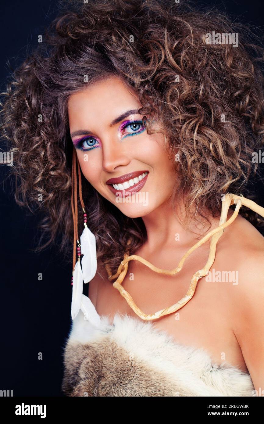 Felice donna bruna sorridente con pelle abbronzata e capelli ondulati sani ritratto studio Foto Stock