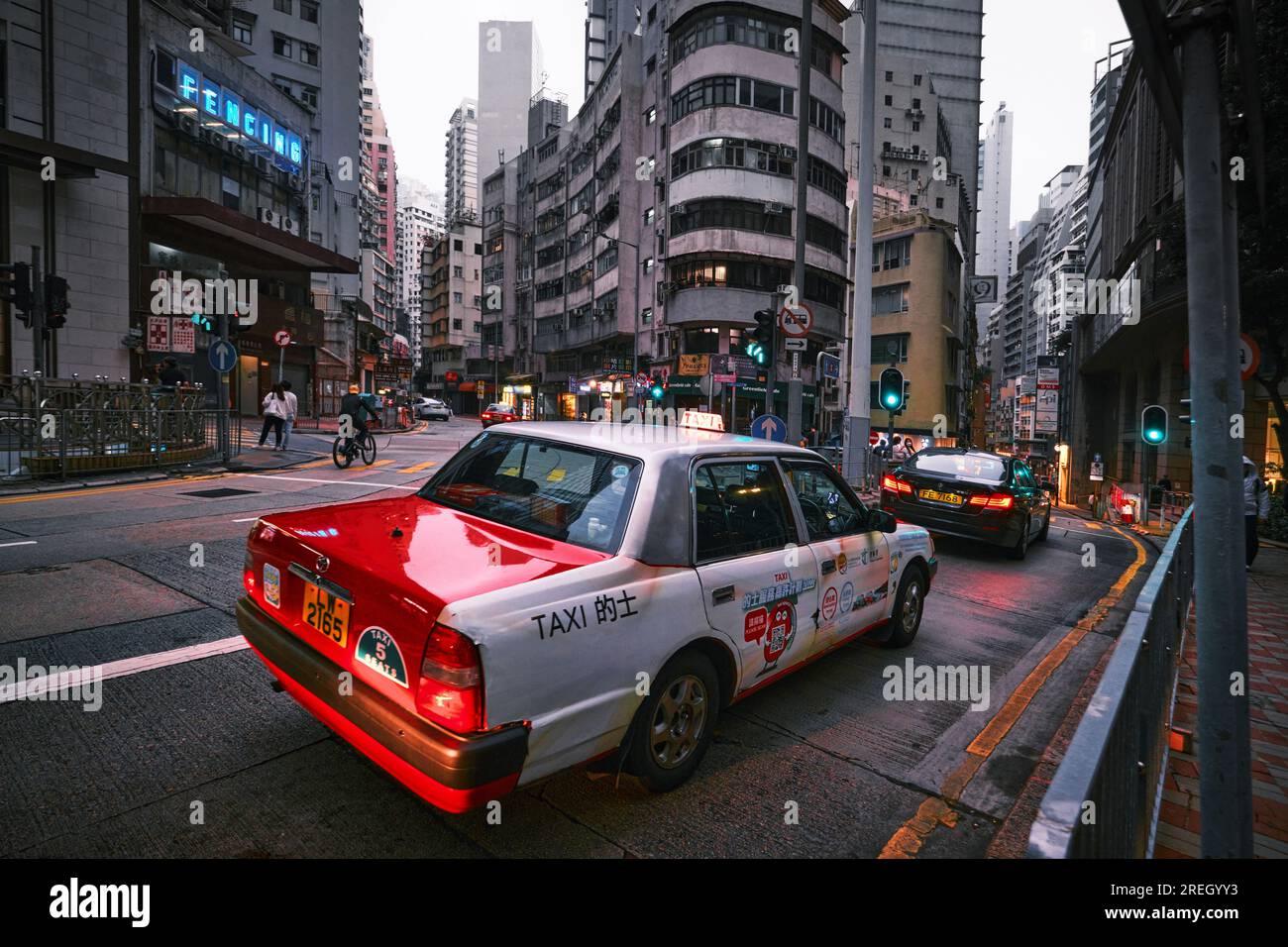 Hong Kong, Cina - 24 aprile 2023: Taxi rosso la sera in Hong Kong Street Foto Stock