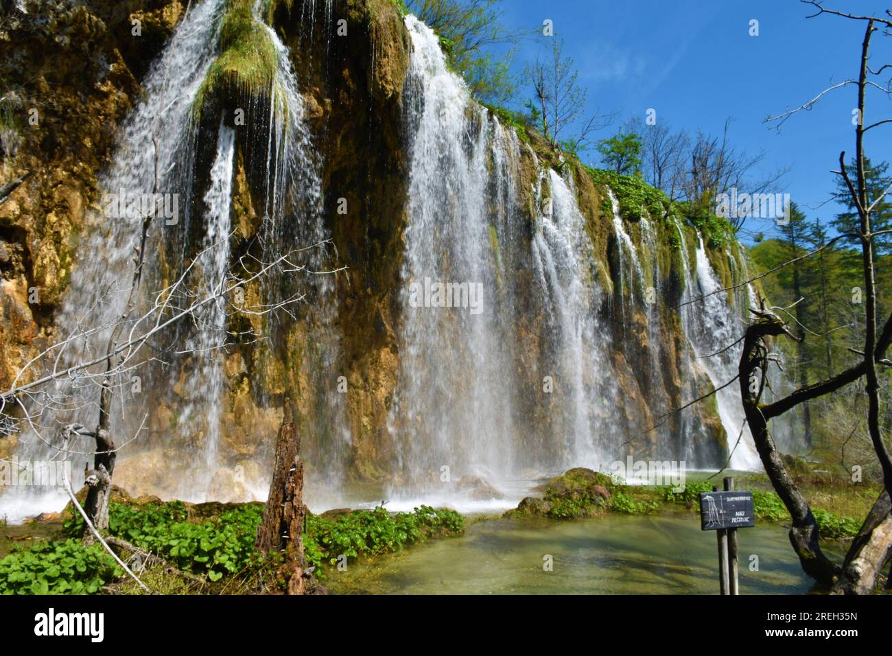Cascata del Mali Prštavac nei laghi di Plitvice nella contea di Lika-Senj, Croazia, con un cartello con il nome della cascata e la parola cascata in croazia Foto Stock