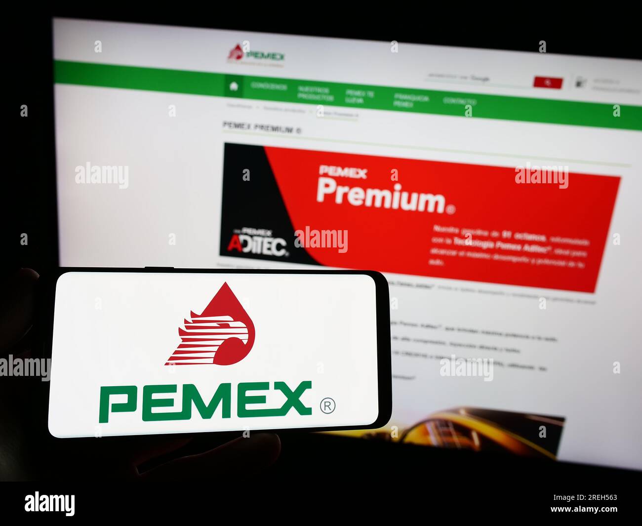 Persona che possiede uno smartphone con il logo della compagnia petrolifera Petroleos Mexicanos (Pemex) sullo schermo di fronte al sito Web. Concentrarsi sul display del telefono. Foto Stock