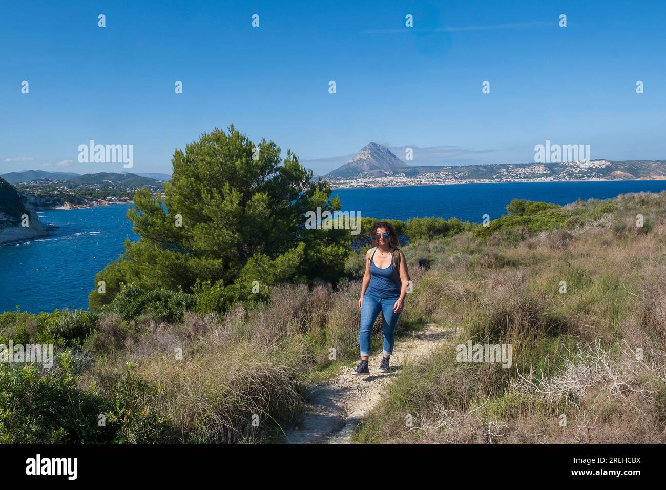 Una donna a Javea (Xabia) a Cap prim e guarda al mare. Foto Stock