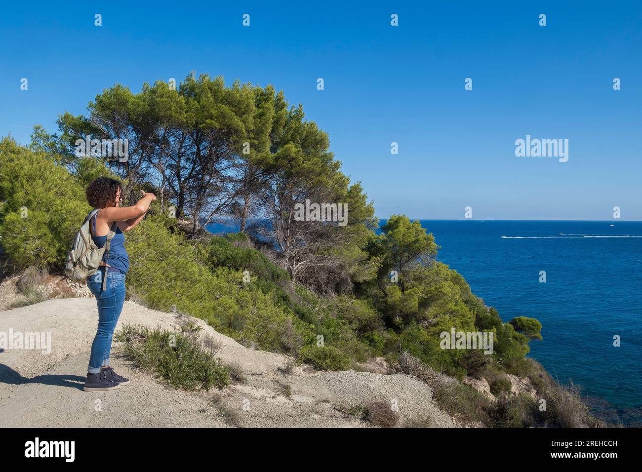 Una donna a Javea (Xabia) a Cap prim e guarda al mare. Foto Stock