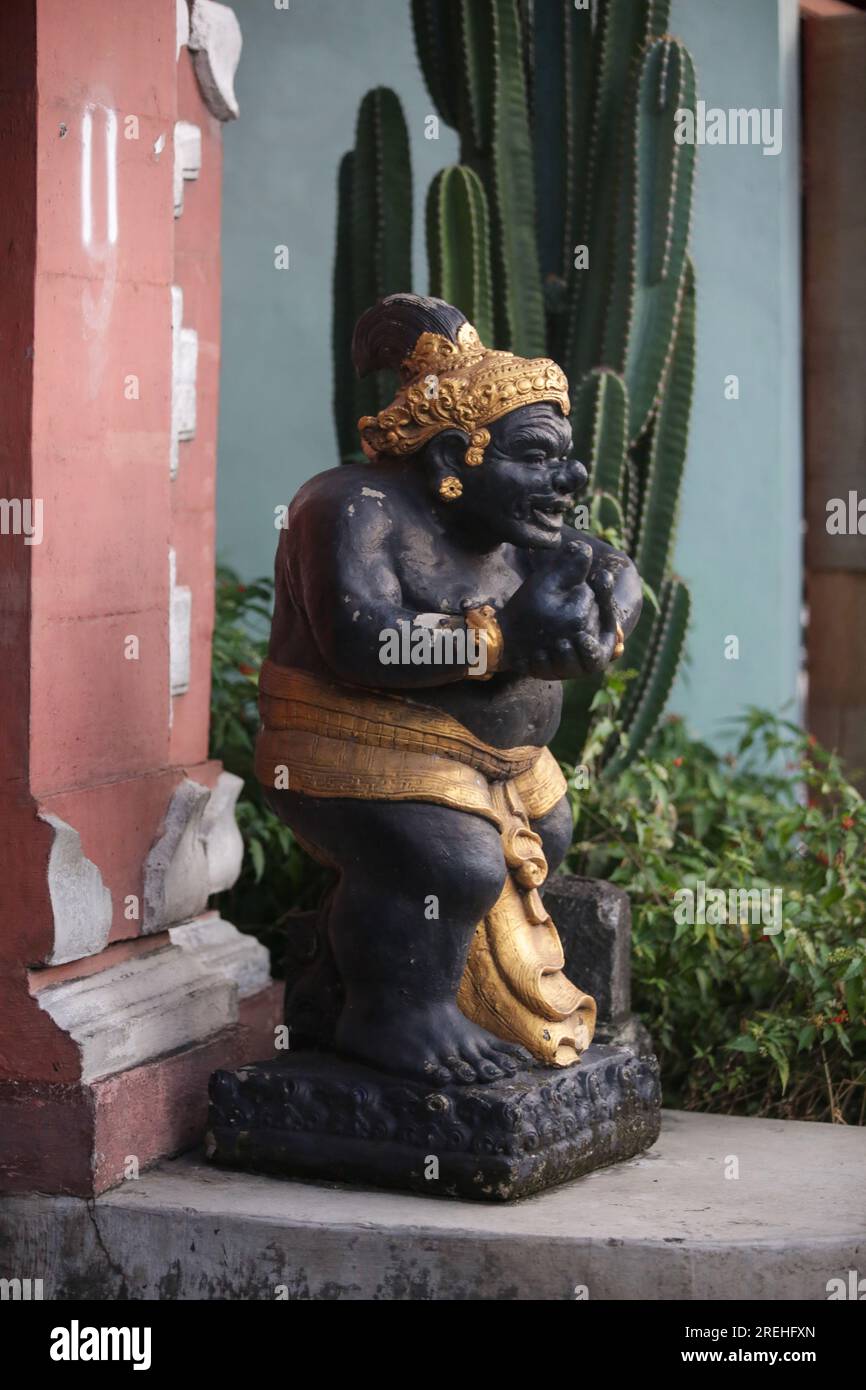 Statua balinese accanto alla porta della casa tradizionale Foto Stock