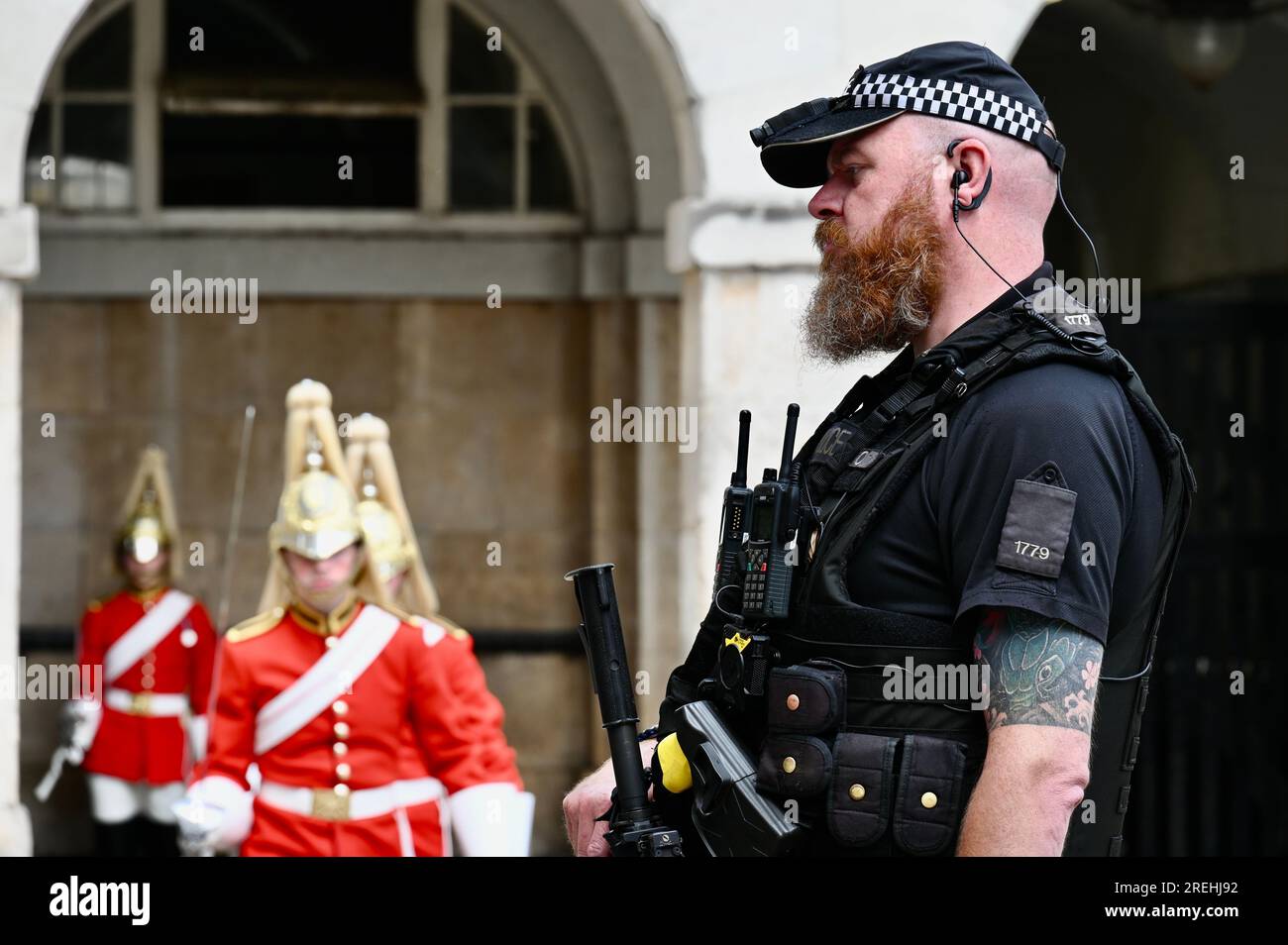 Ufficiale di polizia Armed Police Protecting the Changing of the King's Life Guard , Horse Guards Parade, Whitehall, Londra, Regno Unito Foto Stock
