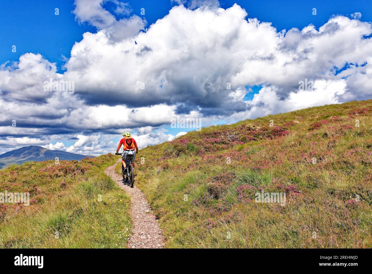 Knockan Crag West Highlands Geopark Scozia in estate un ciclista solitario su un'alta falesia Foto Stock