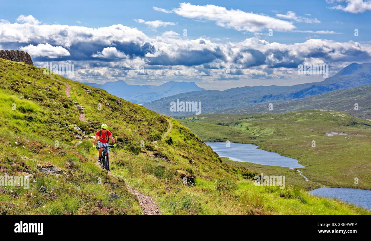 Knockan Crag West Highlands Geopark Scozia in estate un ciclista solitario sul sentiero dal punto di vista murato Foto Stock