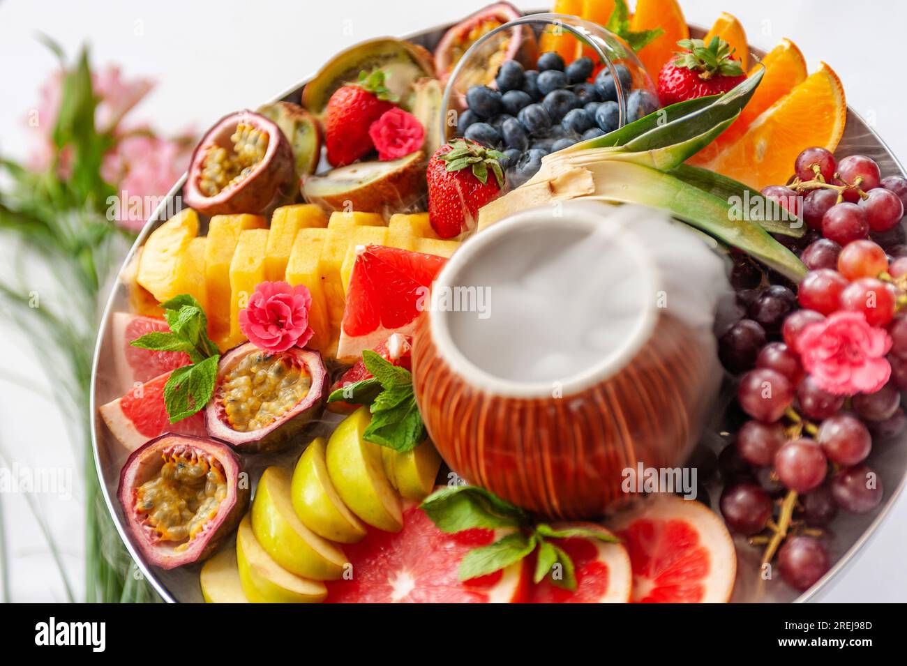 Vassoio assortito di frutta cruda e frutti di bosco sul piatto, sul tavolo bianco Foto Stock