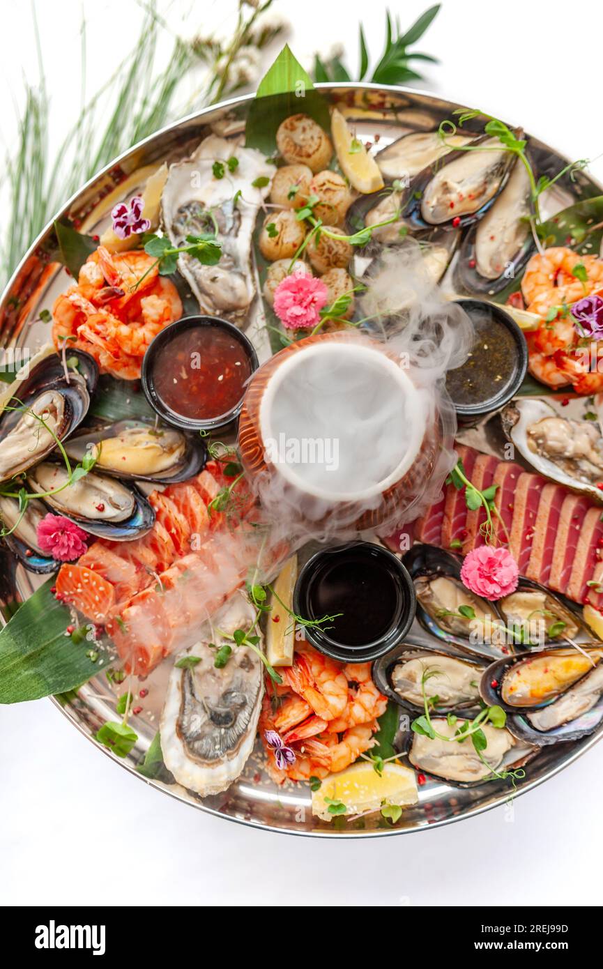Piatto di pesce fresco con cozze, ostriche, capesante, salmone e tonno Foto Stock