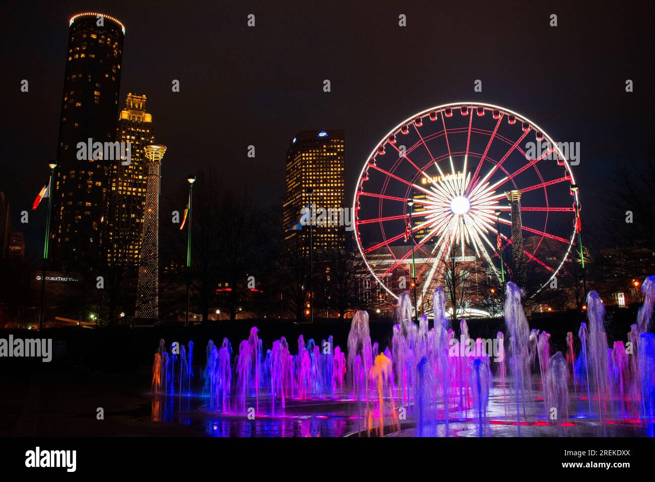 Le colorate luci delle fontane completano la ruota panoramica SkyView nel Centennial Olympic Park di Atlanta di notte. Foto Stock