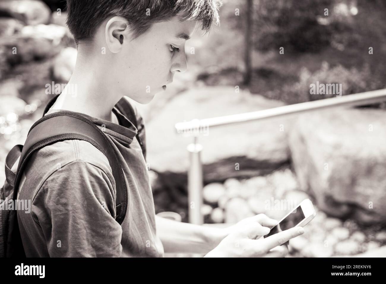 Un adolescente sta guardando uno smartphone Foto Stock