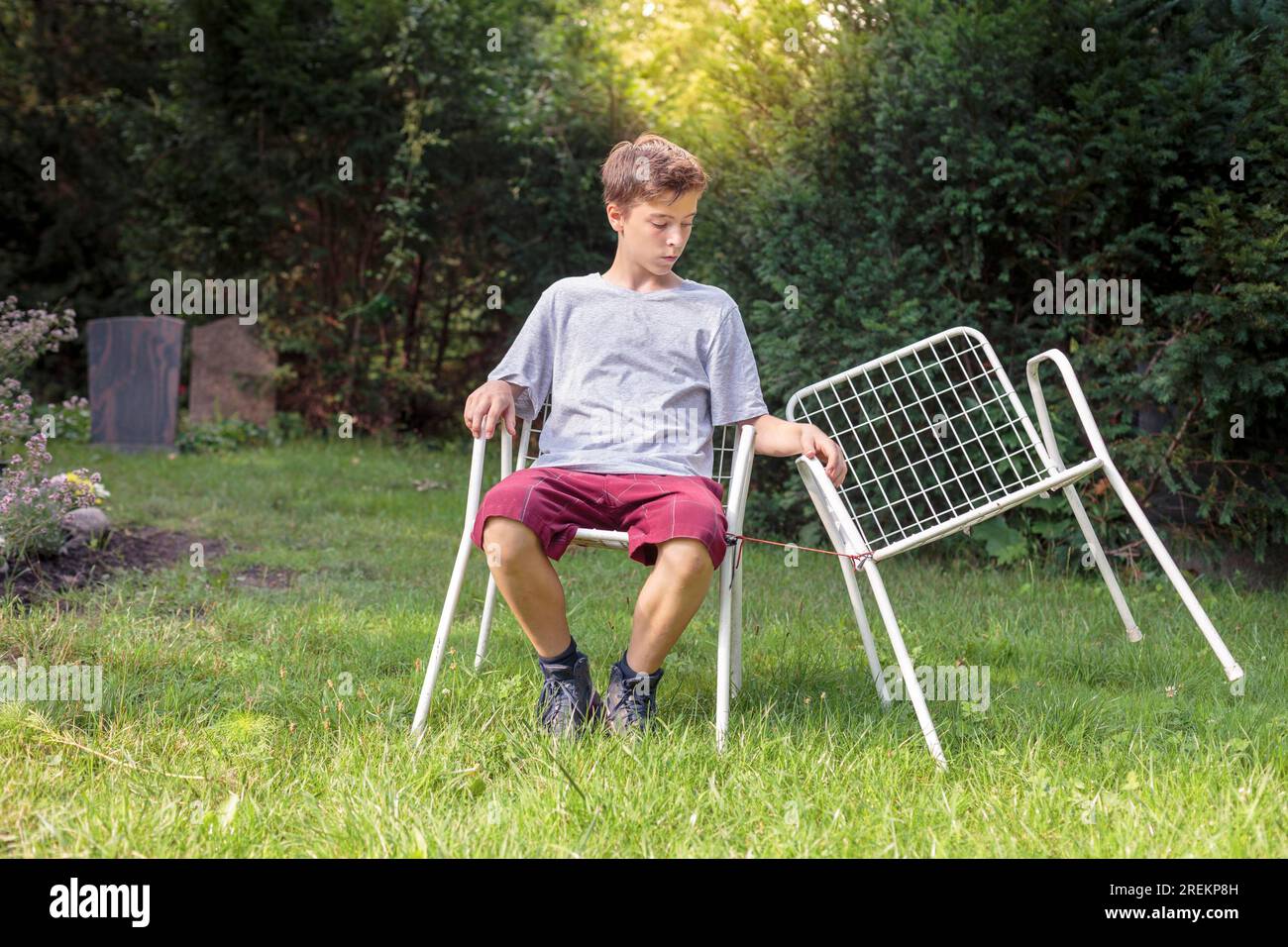 Ragazzo adolescente solitario con due sedie Foto Stock