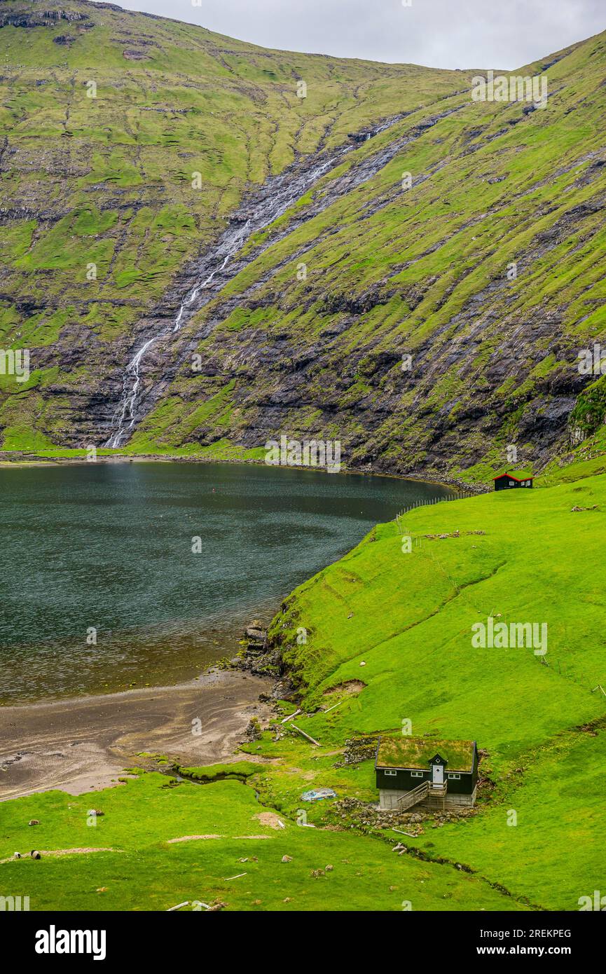 Grasstop roof House davanti a una cascata, Saksun, Streymoy, isole Faroe, Danimarca Foto Stock