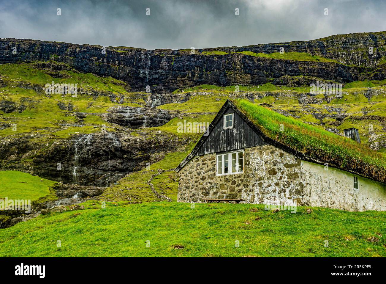 Grasstop roof House davanti a una cascata, Saksun, Streymoy, isole Faroe, Danimarca Foto Stock