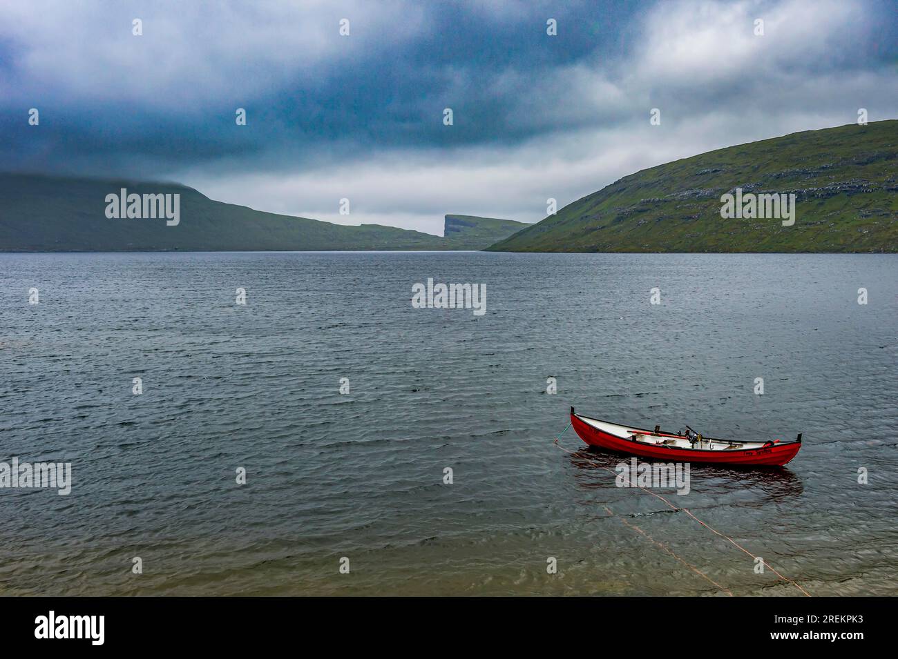 Piccola barca rossa in un lago a Vagar, isole Faroe, Danimarca Foto Stock