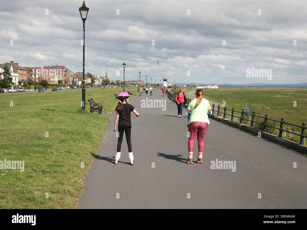 Due ragazze su rollerblade, che corrono lungo la Promenade, Lytham St Annes, Lancashire, Regno Unito, Europa Foto Stock