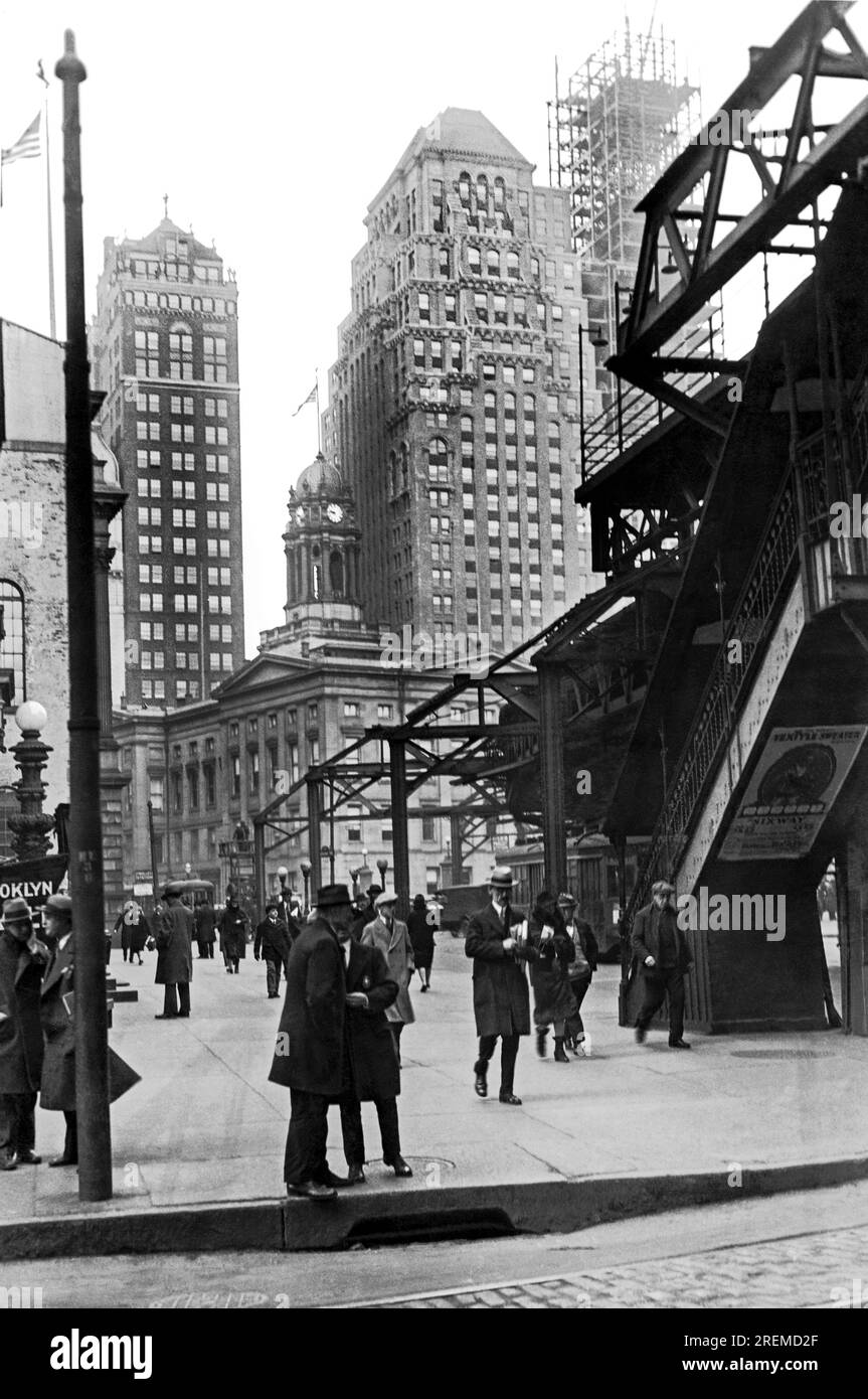 New York, New York: c. 1930 il treno sopraelevato si trova in netto rilievo vicino al Borough Hall di Brooklyn, a sua volta circondato da grattacieli sempre più torreggianti. Foto Stock
