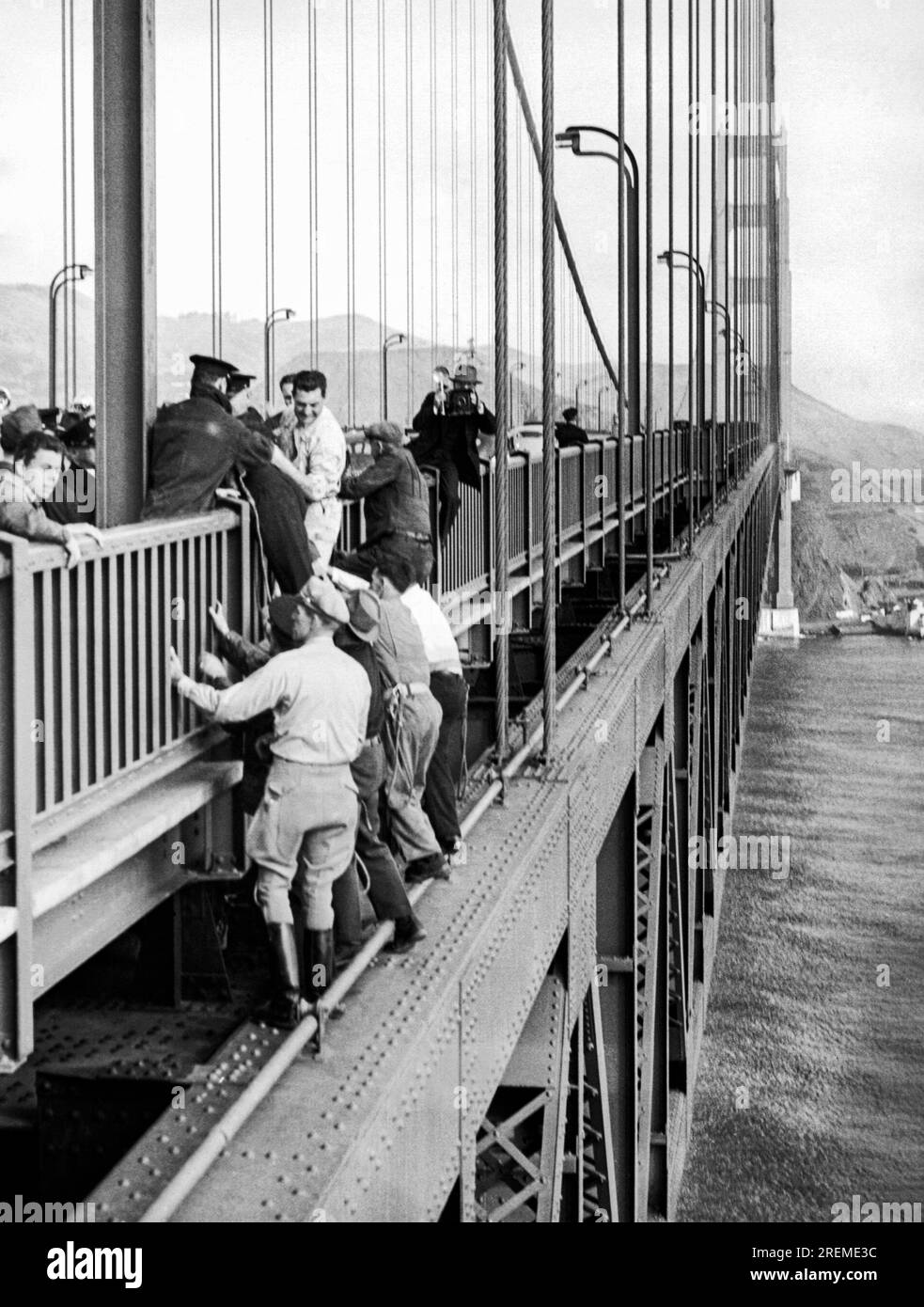 San Francisco, California: 11 ottobre 1941 soccorritori che sollevano un uomo sulla ringhiera che stava tentando di suicidarsi sul Golden Gate Bridge. Foto Stock
