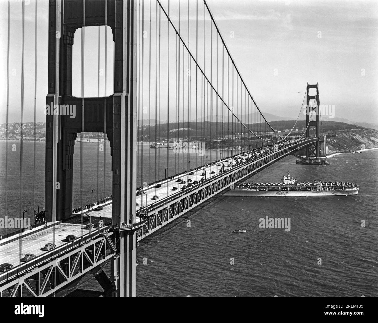 San Francisco, California: 28 maggio 1937 Una portaerei della Marina degli Stati Uniti che passa sotto il Golden Gate Bridge durante le cerimonie del giorno di apertura per il traffico sul ponte. Foto Stock