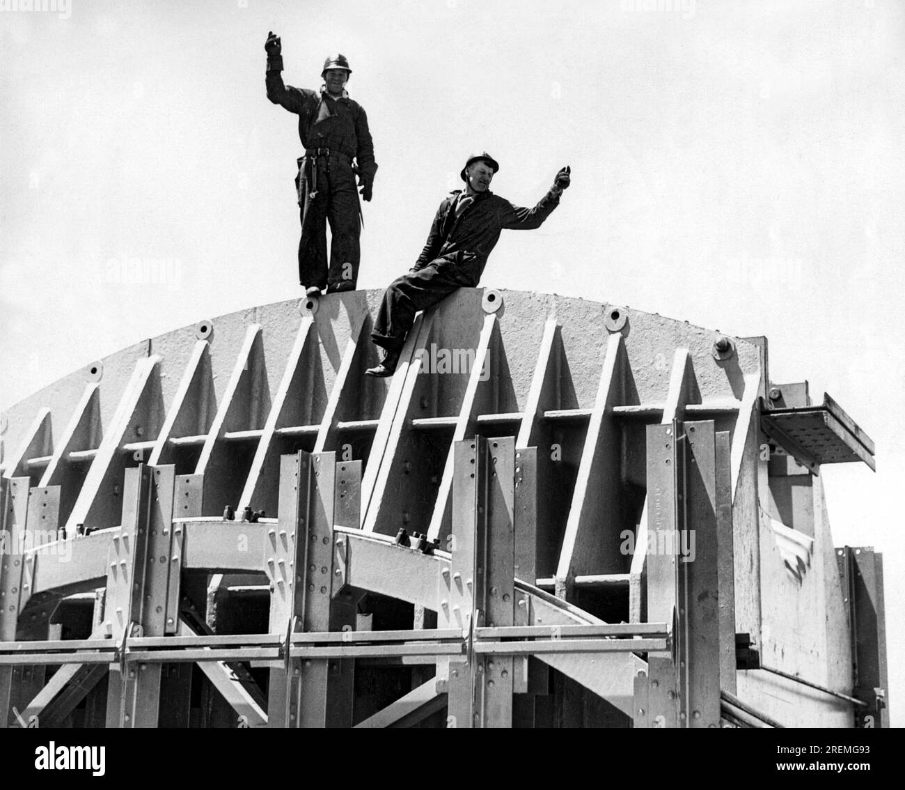 San Francisco, California: 1934 il Golden Gate Bridge è in costruzione con due lavoratori in sella alla Marin Tower, a 746 metri sopra l'acqua. Foto Stock