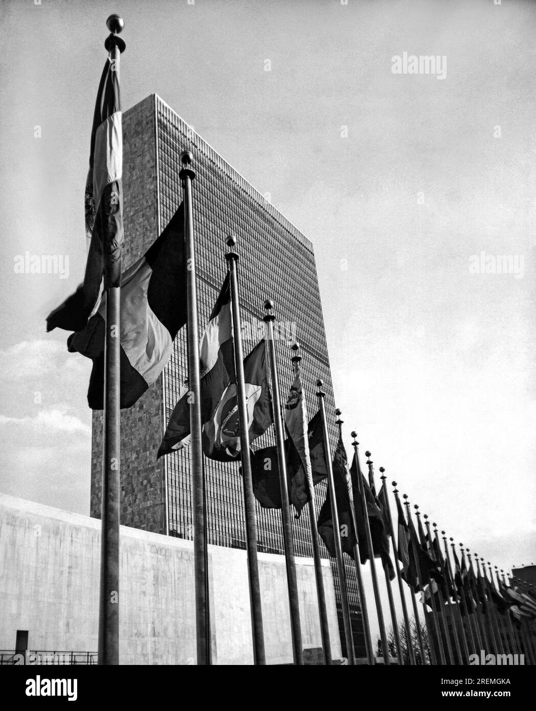 New York, New York: Aprile 1957 Bandiere che rappresentano i paesi membri dell'onda delle Nazioni Unite in esposizione permanente di fronte al General Assembly Building nel centro di Manhattan. Foto Stock