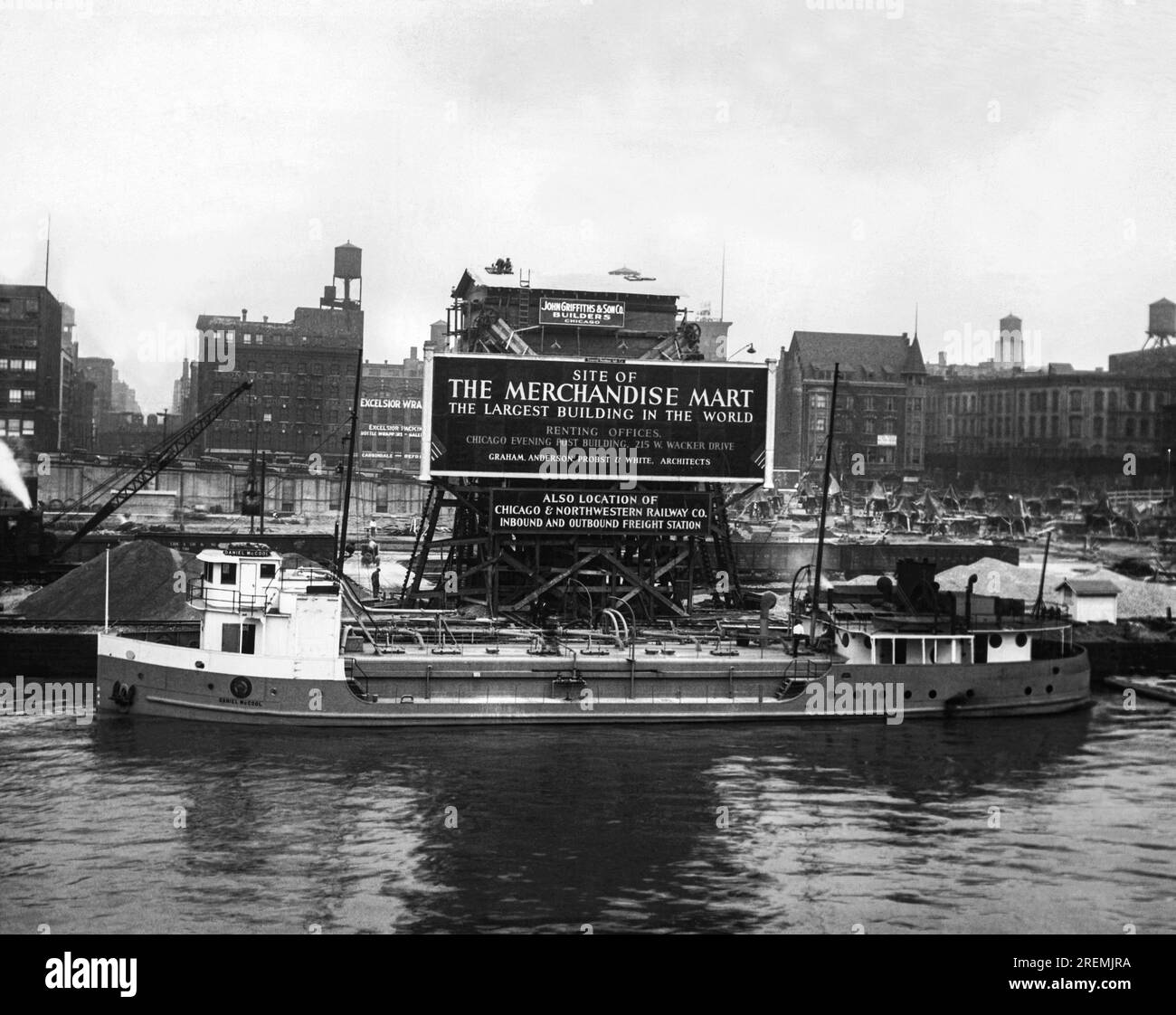 Chicago, Illinois: 10 settembre 1928 inizio della costruzione del Merchandise Mart, presto il più grande edificio del mondo. La barca d'acciaio di fronte, la Daniel McCool, ha appena sparato 2 milioni di libbre di cemento nel sito. Foto Stock
