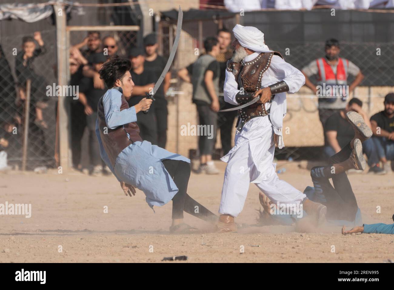 Shiite Muslims re-enact the seventh century battle of Karbala during activities marking the holy day of Ashoura, in the Shiite neighborhood of Sadr City, Baghdad, Iraq, Saturday, July. 29, 2023. Ashoura is the annual Shiite Muslim commemoration marking the death of Imam Hussein, the grandson of the Prophet Muhammad, at the Battle of Karbala in present-day Iraq in the 7th century. (AP Photo/Hadi Mizban) Foto Stock