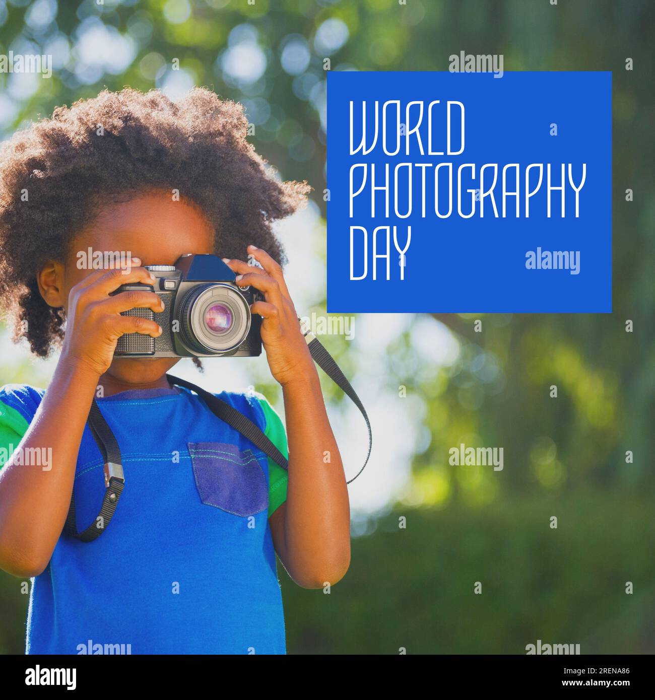 Testo del giorno della fotografia mondiale in bianco su blu su ragazza afro-americana che usa la fotocamera in un giardino soleggiato Foto Stock