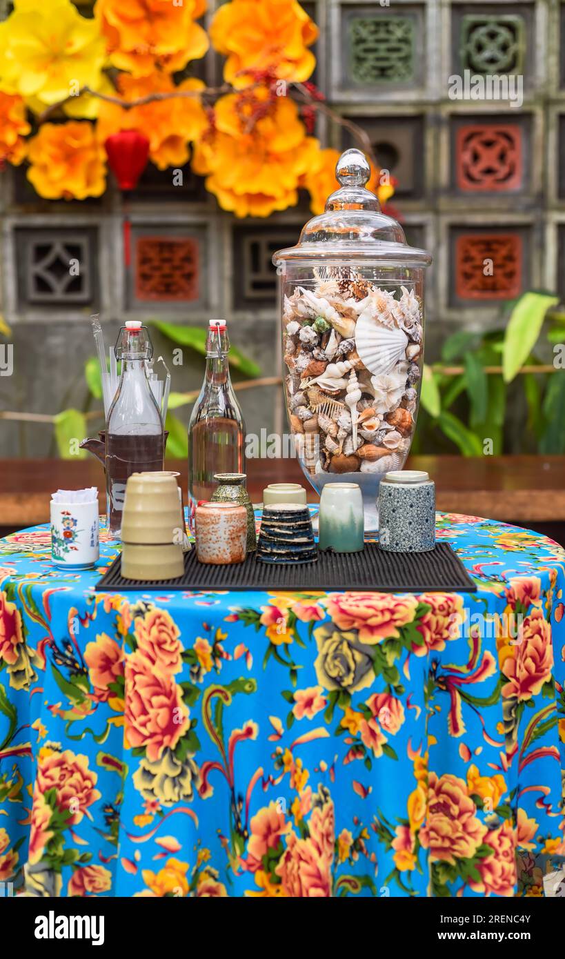 Tavolo decorato con tazza e bottiglia d'acqua, conchiglie, rituale buddista religioso in Vietnam prima del Tet (Capodanno cinese) Foto Stock