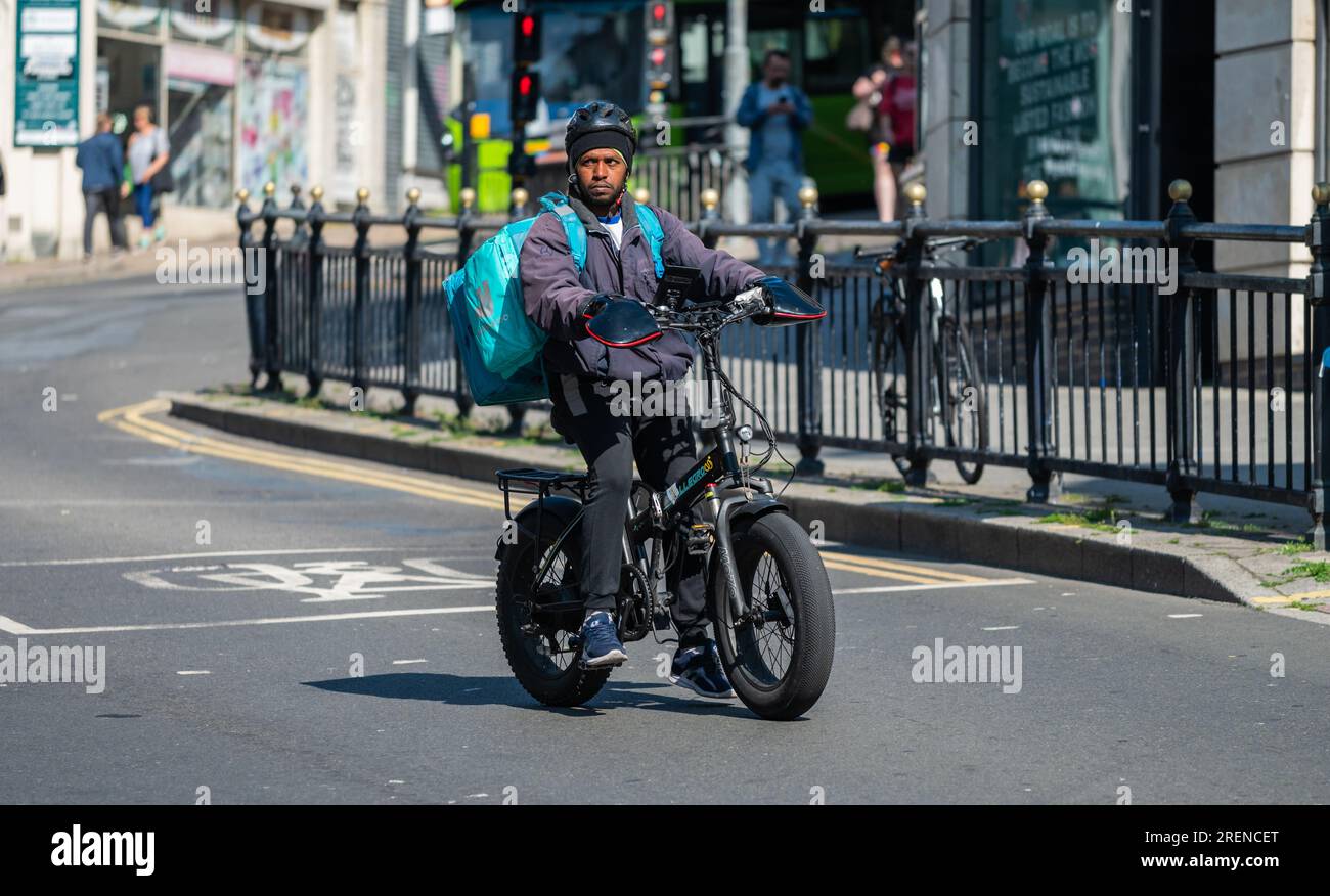 Ciclista in bicicletta da città che consegna cibo Deliveroo, ordinato online, Regno Unito. Foto Stock