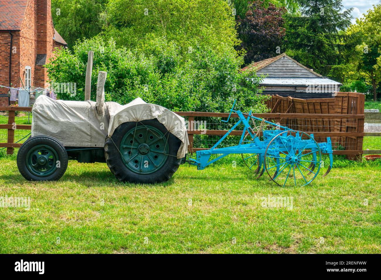 trattore con copertura e aratro parcheggiato di fronte all'azienda agricola in sud africa Foto Stock