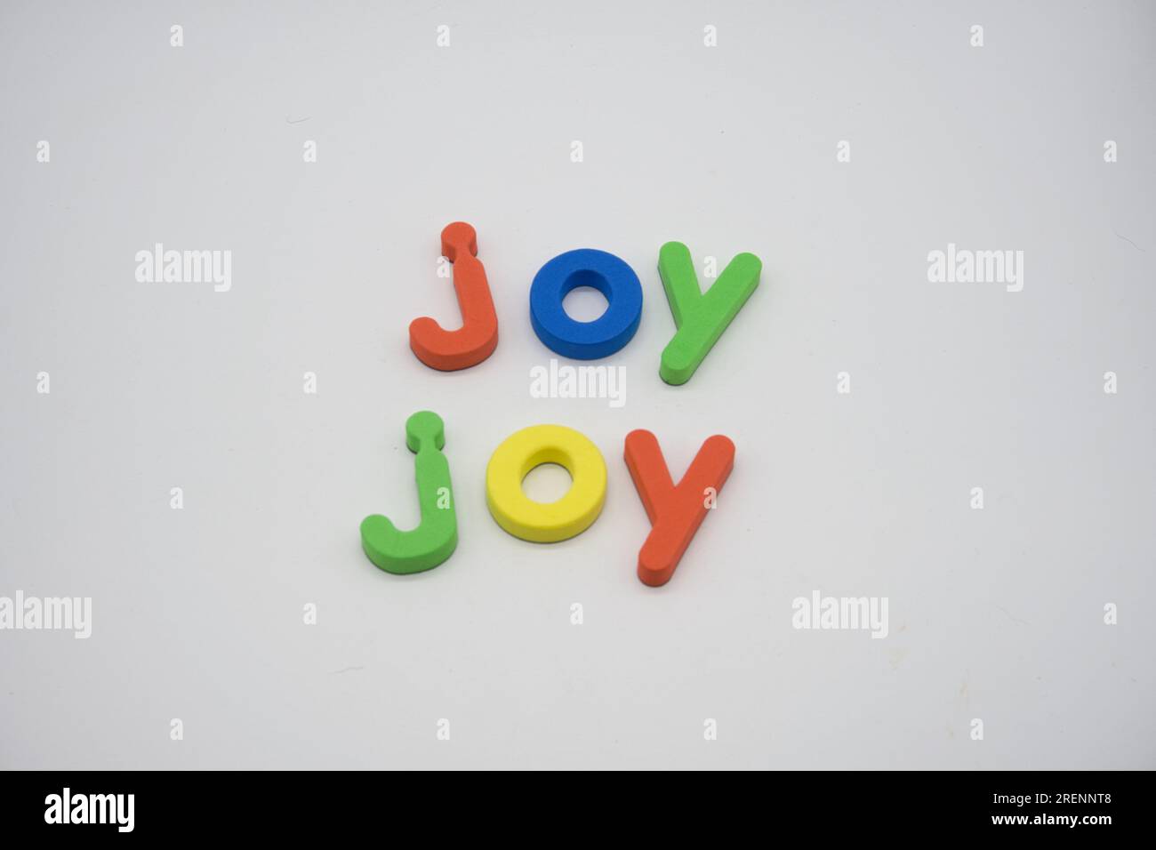 Magneti per frigorifero multicolore che scrivono Joy in caratteri alfabetici minuscoli Foto Stock