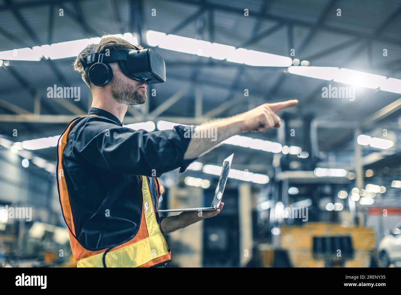 Ingegnere maschio utilizzando la tecnologia di realtà virtuale in realtà virtuale nella moderna fabbrica di warehouse di nuova progettazione innovativa Foto Stock