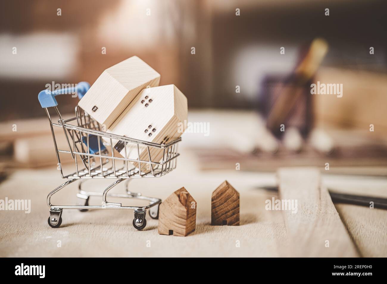 piccolo modello di casa in legno nel carrello della spesa in vendita comprare affittare nuova casa alloggio concetto di business. Foto Stock